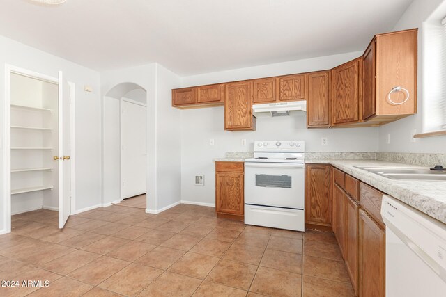 kitchen with sink, white appliances, and light tile patterned flooring