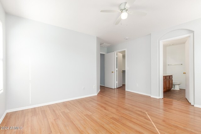 unfurnished bedroom with ensuite bath, ceiling fan, and light hardwood / wood-style floors