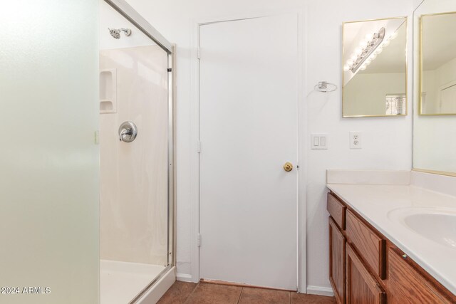 bathroom with tile patterned floors, vanity, and a shower with shower door