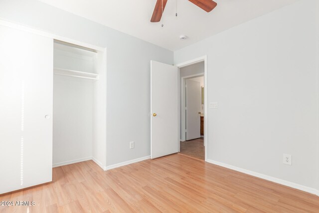 unfurnished bedroom with a closet, light hardwood / wood-style flooring, and ceiling fan