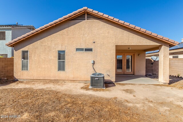 rear view of property featuring french doors, a patio, and central AC unit