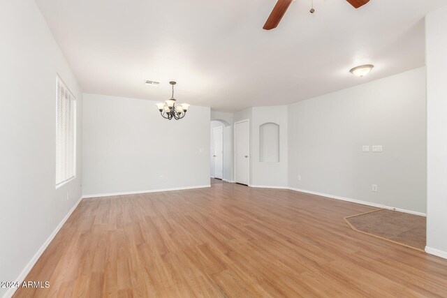 unfurnished room featuring ceiling fan with notable chandelier and light hardwood / wood-style floors