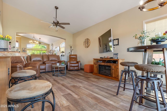 1437 E Glenhaven Dr, Phoenix, AZ 85048 - living room with vaulted ceiling, light wood-style floors, a ceiling fan, arched walkways, and a chandelier