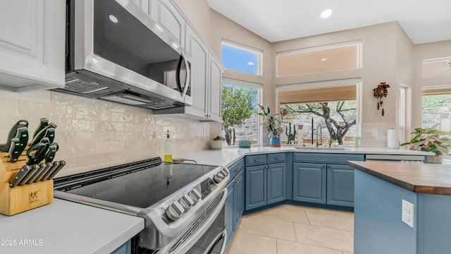 116 E Mountain Sky Ave, Phoenix, AZ 85048 - kitchen featuring stainless steel appliances, blue cabinets, light tile patterned flooring, backsplash, and wooden counters
