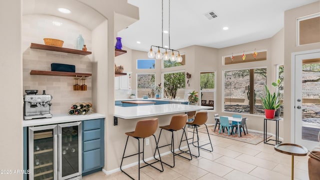 116 E Mountain Sky Ave, Phoenix, AZ 85048 - kitchen with wine cooler, light countertops, healthy amount of natural light, a breakfast bar, and recessed lighting