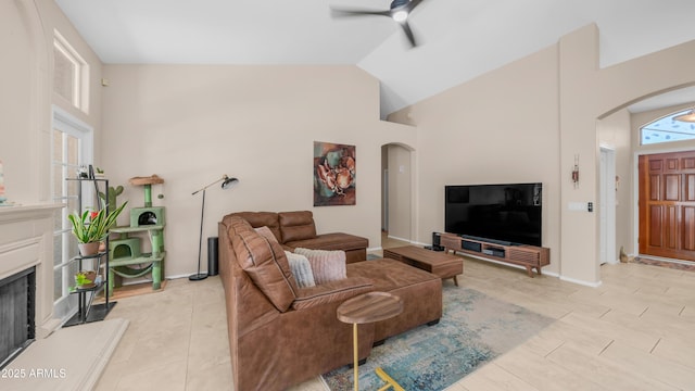 116 E Mountain Sky Ave, Phoenix, AZ 85048 - living area featuring arched walkways, ceiling fan, high vaulted ceiling, a fireplace with raised hearth, and light tile patterned floors