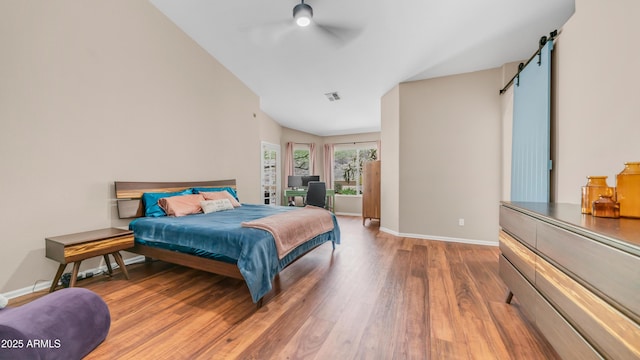 116 E Mountain Sky Ave, Phoenix, AZ 85048 - bedroom featuring a barn door, wood finished floors, ceiling fan, and lofted ceiling