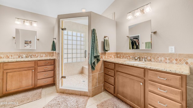 116 E Mountain Sky Ave, Phoenix, AZ 85048 - bathroom with tile patterned flooring, two vanities, a stall shower, and tile walls