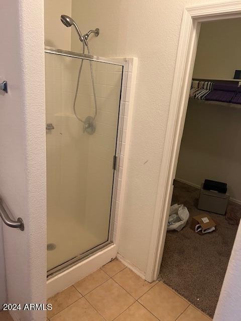 bathroom featuring an enclosed shower and tile floors