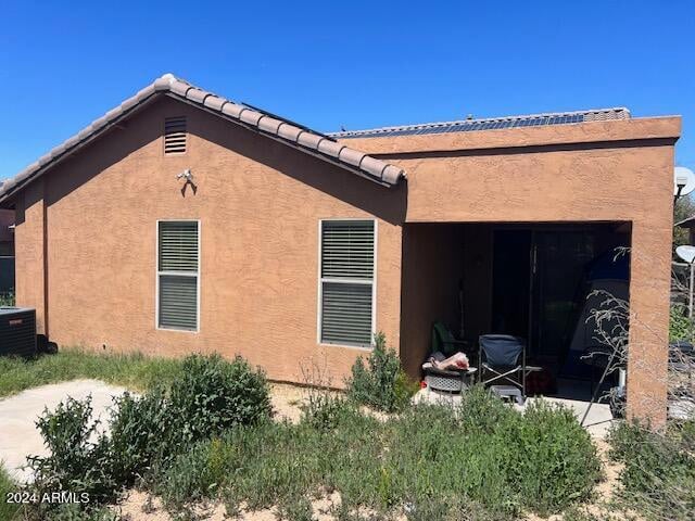 rear view of property with central AC and a garage