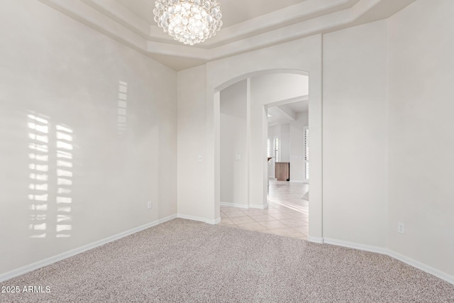 13007 W Tuckey Ct, Glendale, AZ 85307 - unfurnished room with arched walkways, light carpet, a chandelier, light tile patterned floors, and a raised ceiling