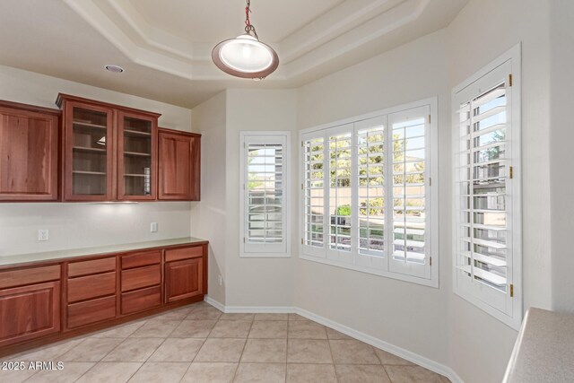 13007 W Tuckey Ct, Glendale, AZ 85307 - unfurnished dining area with plenty of natural light, a tray ceiling, light tile patterned flooring, and baseboards