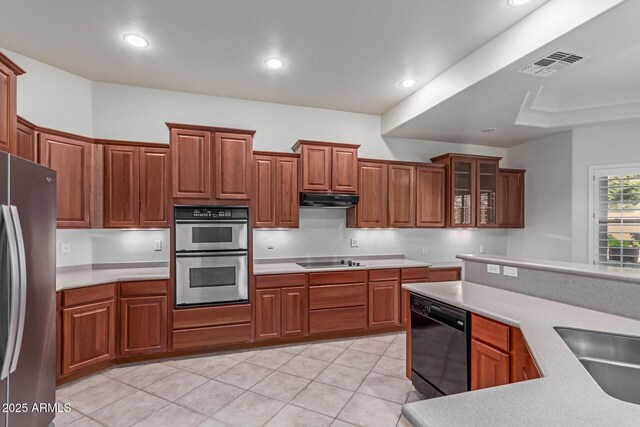 13007 W Tuckey Ct, Glendale, AZ 85307 - kitchen featuring black appliances, under cabinet range hood, light countertops, glass insert cabinets, and recessed lighting