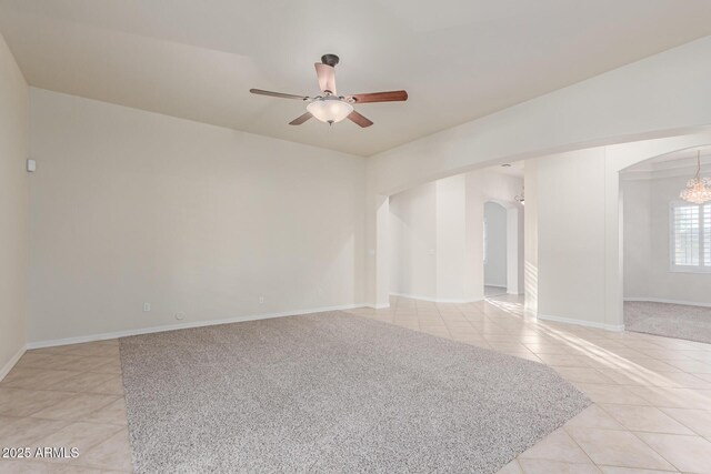 13007 W Tuckey Ct, Glendale, AZ 85307 - empty room featuring arched walkways, light tile patterned flooring, ceiling fan, and baseboards