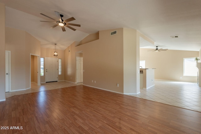 4349 W Cielo Grande, Glendale, AZ 85310 - unfurnished living room featuring a ceiling fan, high vaulted ceiling, light wood finished floors, and baseboards