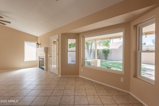 4349 W Cielo Grande, Glendale, AZ 85310 - empty room with a tiled fireplace, ceiling fan, lofted ceiling, light tile patterned flooring, and baseboards