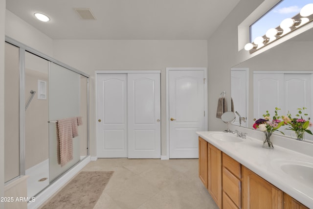 bathroom featuring a shower with door and vanity