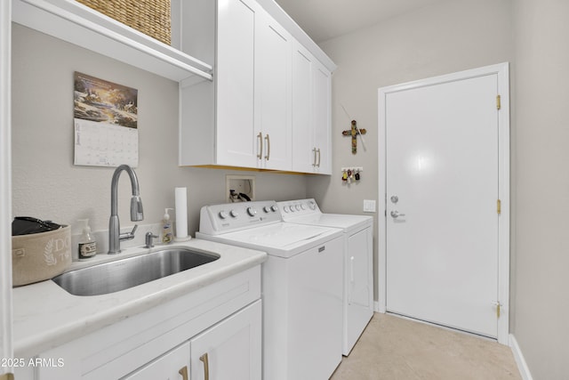 clothes washing area featuring cabinets, sink, and independent washer and dryer