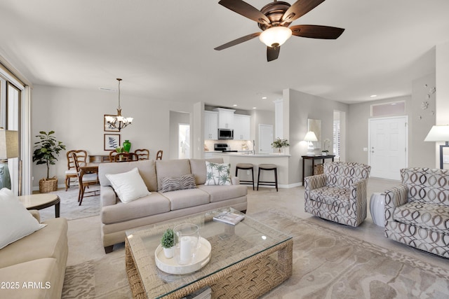 living room with ceiling fan with notable chandelier