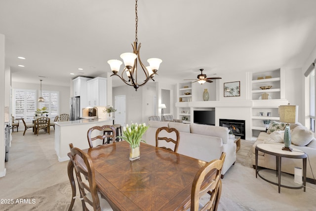 dining room with sink, built in features, and ceiling fan