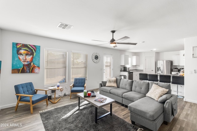 living room with light wood-type flooring and ceiling fan