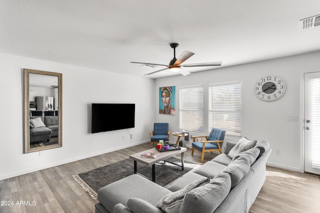 living room with ceiling fan, light wood-type flooring, and a healthy amount of sunlight