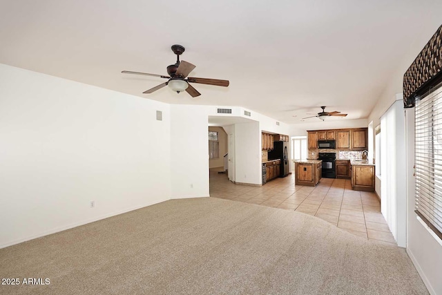 14833 S 14th Pl, Phoenix, AZ 85048 - unfurnished living room featuring visible vents, baseboards, ceiling fan, light colored carpet, and a sink