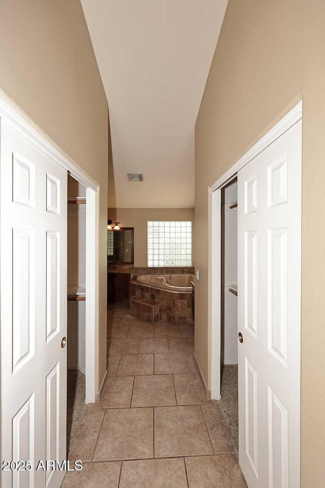14833 S 14th Pl, Phoenix, AZ 85048 - corridor with baseboards, visible vents, light tile patterned floors, and lofted ceiling