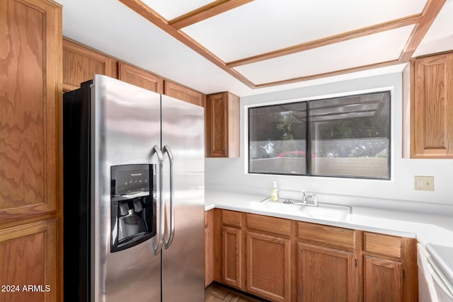 kitchen featuring sink, stove, and stainless steel refrigerator with ice dispenser