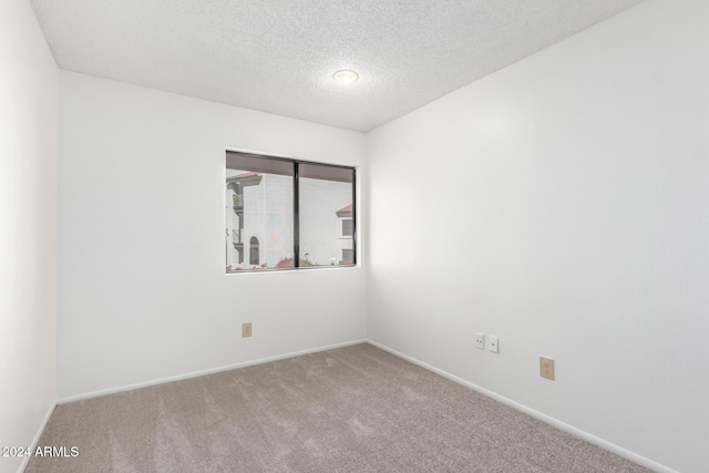 carpeted spare room with a textured ceiling