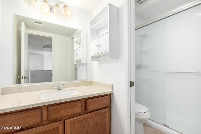 bathroom featuring vanity, toilet, and an enclosed shower