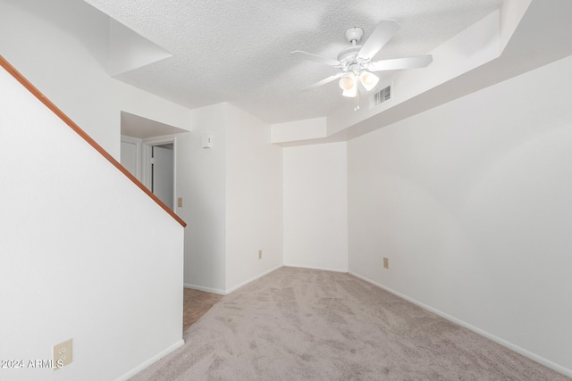 carpeted empty room featuring ceiling fan and a textured ceiling