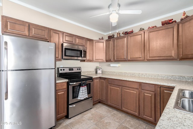 kitchen with appliances with stainless steel finishes, sink, ceiling fan, light tile patterned floors, and crown molding