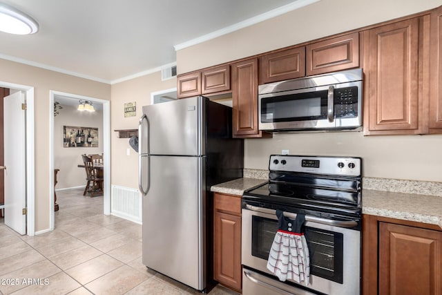 kitchen featuring light tile patterned floors, appliances with stainless steel finishes, and crown molding