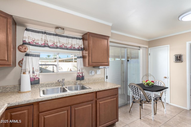 kitchen featuring sink, crown molding, and light tile patterned flooring