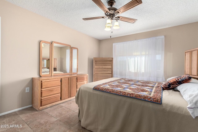 tiled bedroom with ceiling fan and a textured ceiling