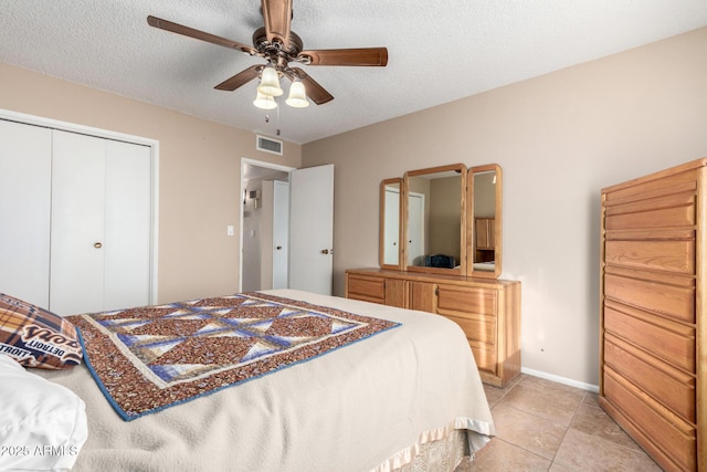 bedroom featuring a textured ceiling, ceiling fan, light tile patterned flooring, and a closet