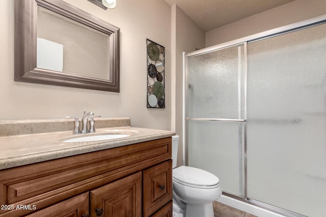 bathroom with an enclosed shower, vanity, and toilet