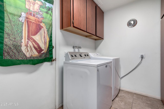 washroom featuring cabinets, light tile patterned floors, and washer and clothes dryer