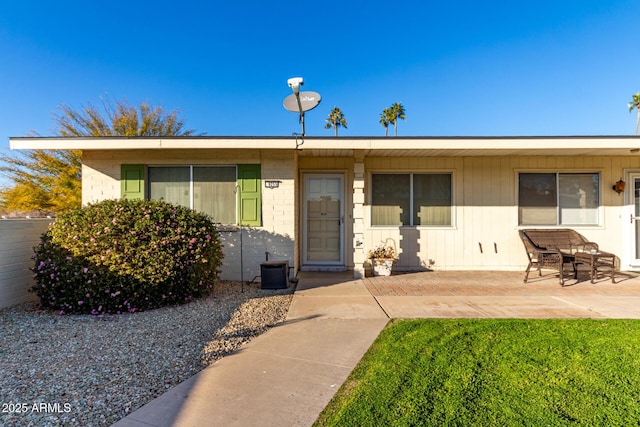 view of front of property with a patio area and central AC