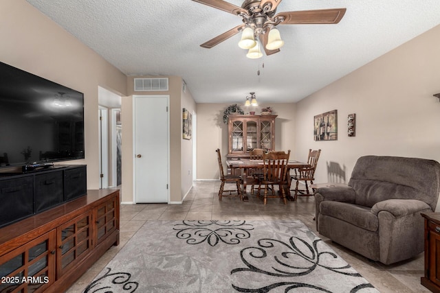 tiled living room with a textured ceiling and ceiling fan