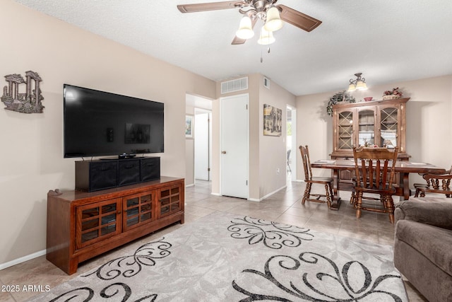 tiled living room with ceiling fan and a textured ceiling