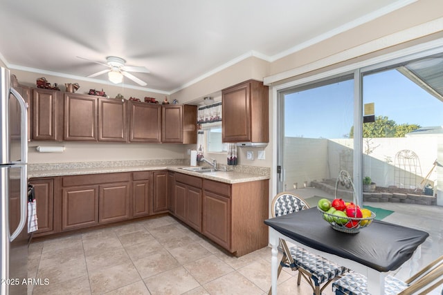 kitchen with stainless steel fridge, ceiling fan, light tile patterned flooring, ornamental molding, and sink