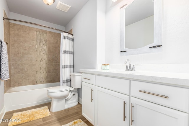 full bathroom featuring hardwood / wood-style flooring, shower / tub combo with curtain, vanity, and toilet