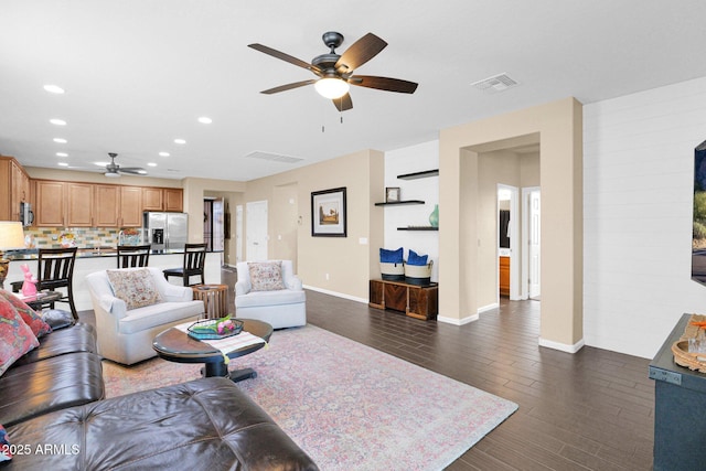 living room with dark wood-style floors, baseboards, visible vents, and recessed lighting