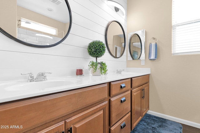 full bathroom featuring double vanity, a sink, visible vents, and baseboards