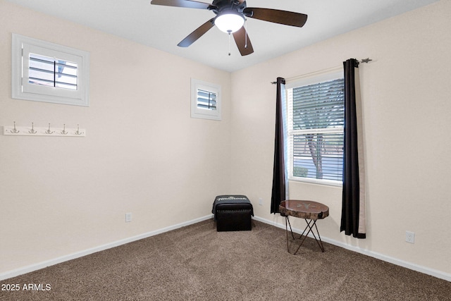 carpeted empty room with baseboards and a ceiling fan