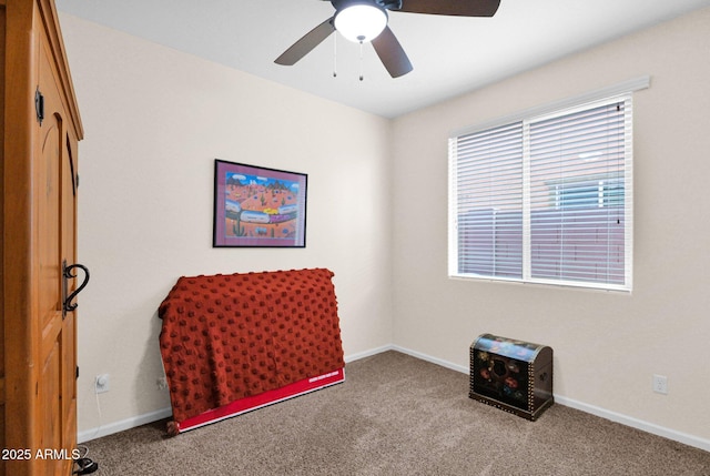 interior space with carpet floors, a healthy amount of sunlight, ceiling fan, and baseboards