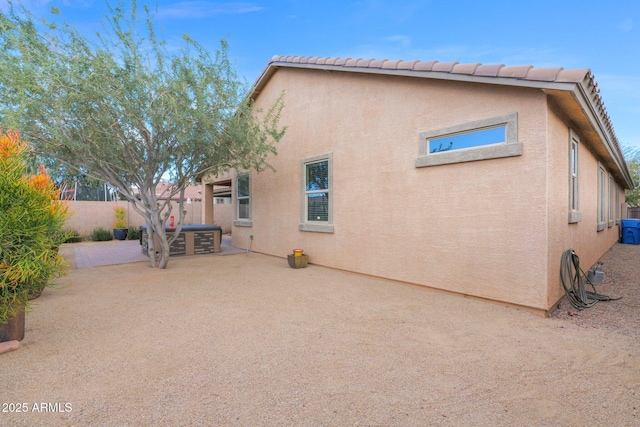 rear view of house with a patio, a fenced backyard, a tiled roof, and stucco siding