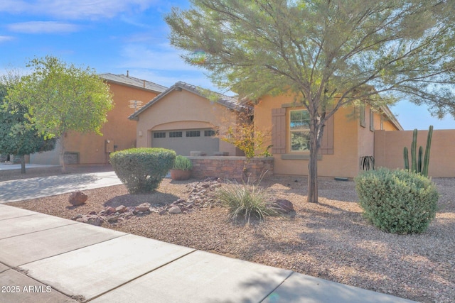 view of front of home with a garage, concrete driveway, and stucco siding